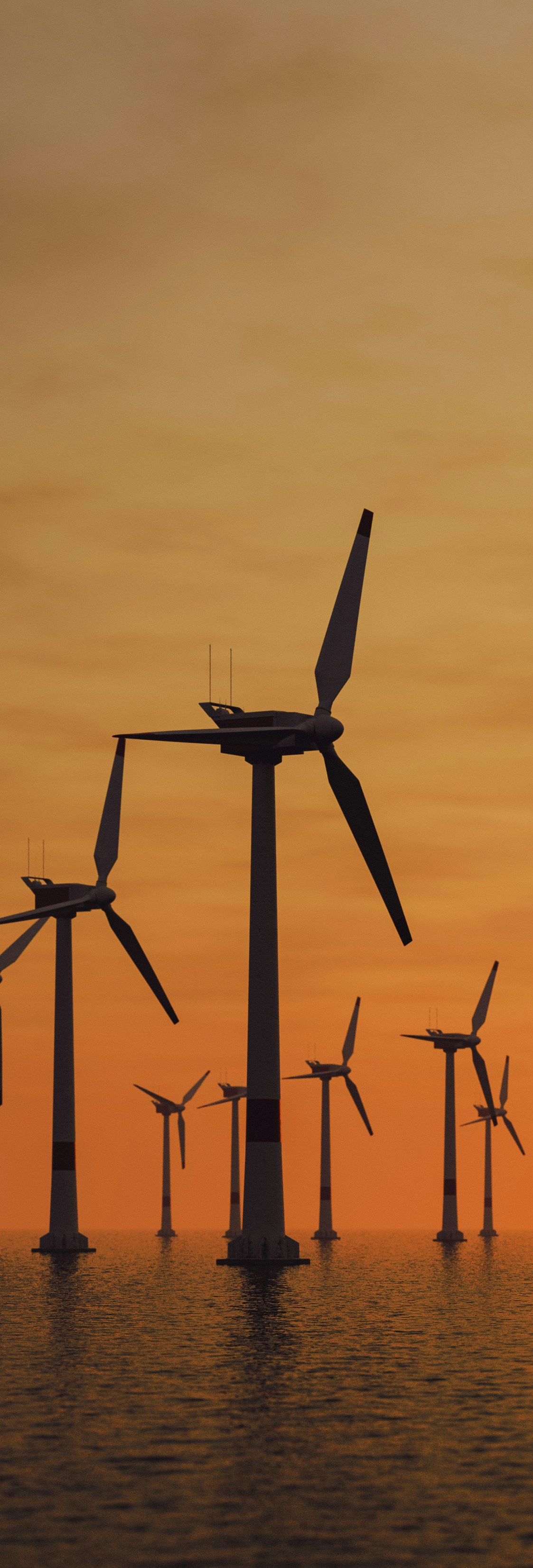 Offshore wind turbines standing in open water at sunset