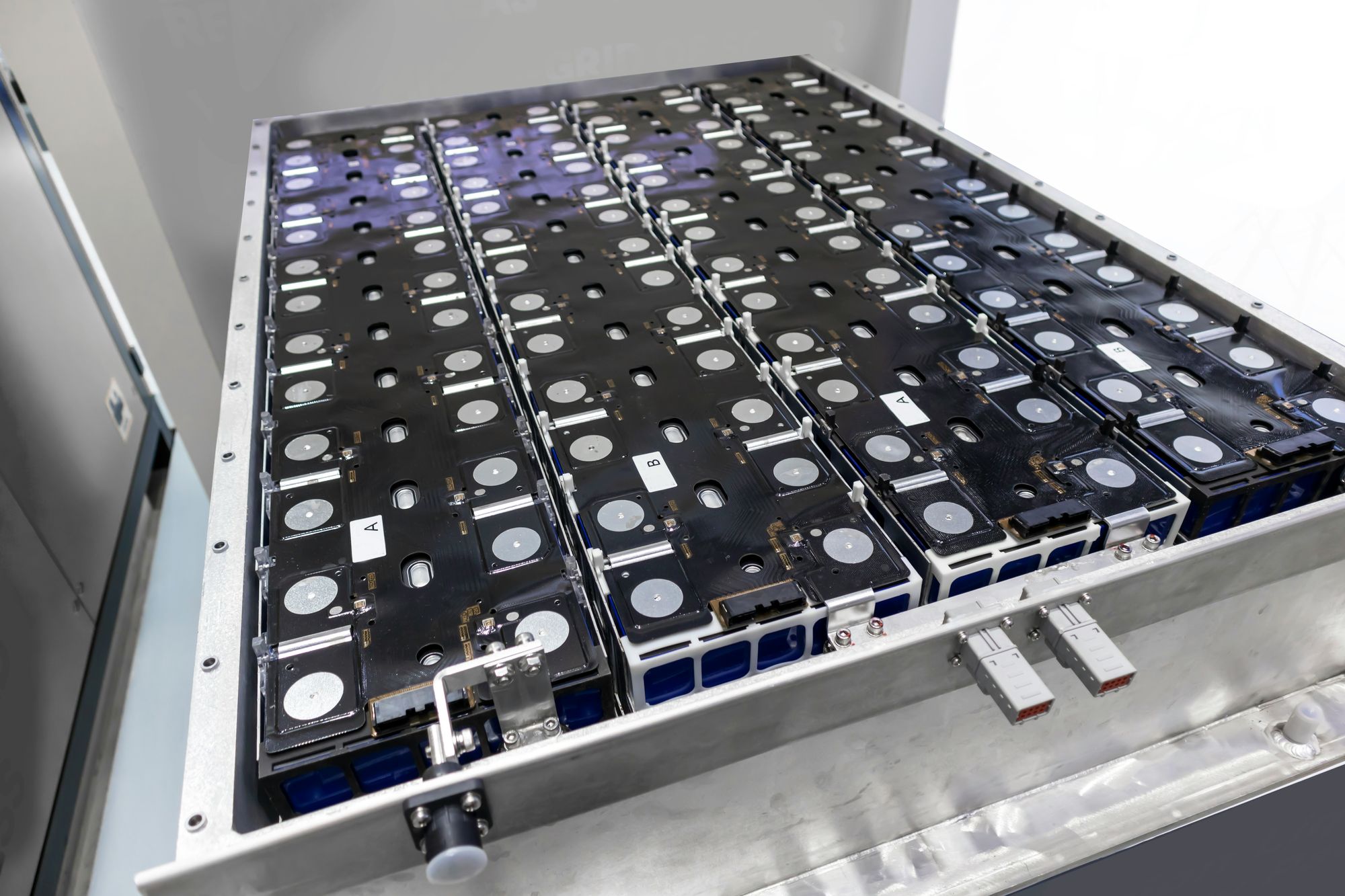 Close-up of cylindrical lithium-ion battery cells in an industrial manufacturing context — representing the electrode materials research that determines capacity retention, cycle life, and energy density in next-generation EV battery packs