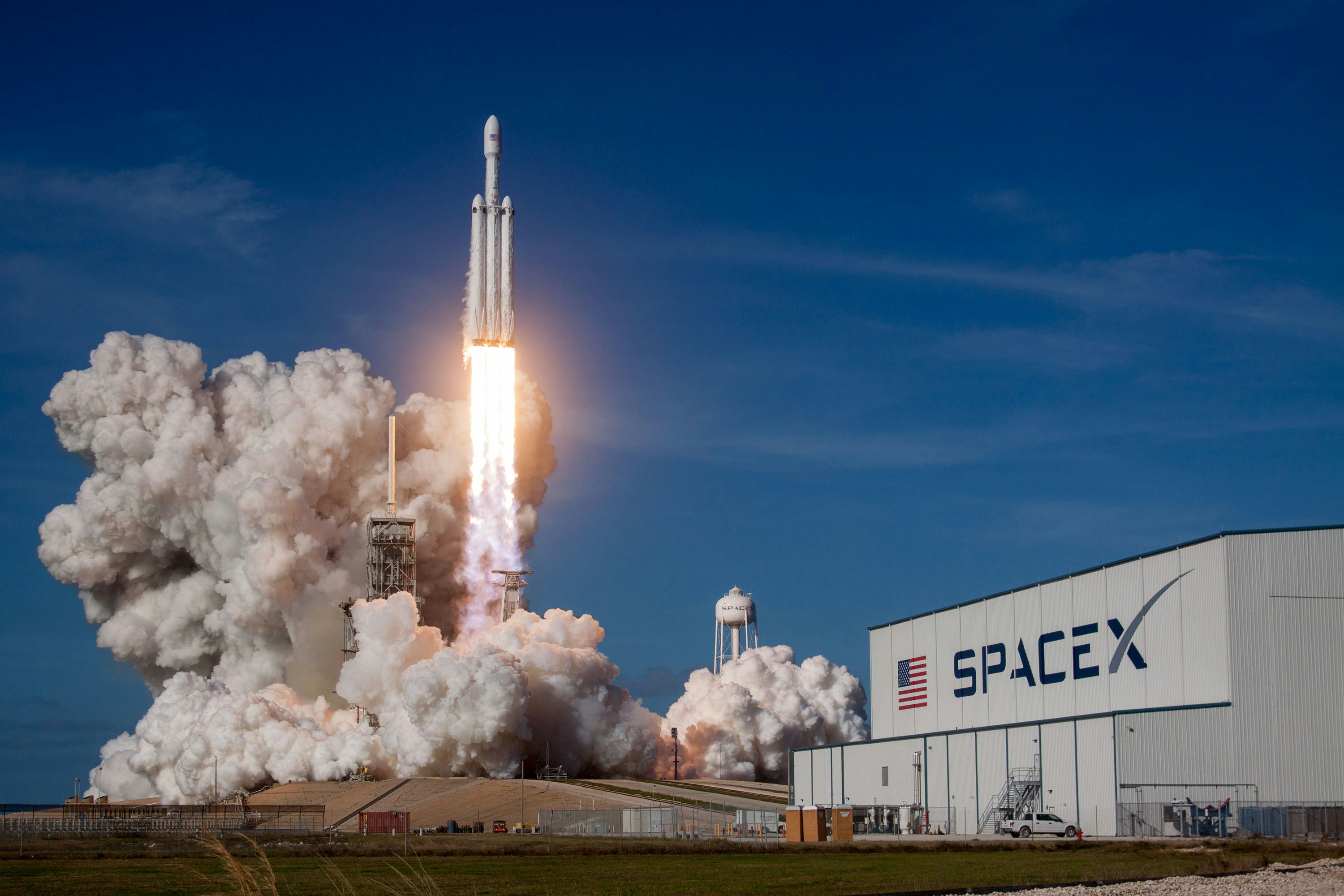 Rocket launching at night with brilliant engine flame against a dark sky — representing SpaceX's transition from a private launch company to a publicly traded AI compute and satellite connectivity platform