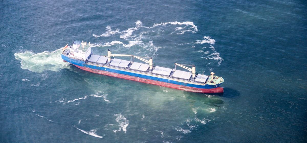 Cargo ship underway at sea, aerial view