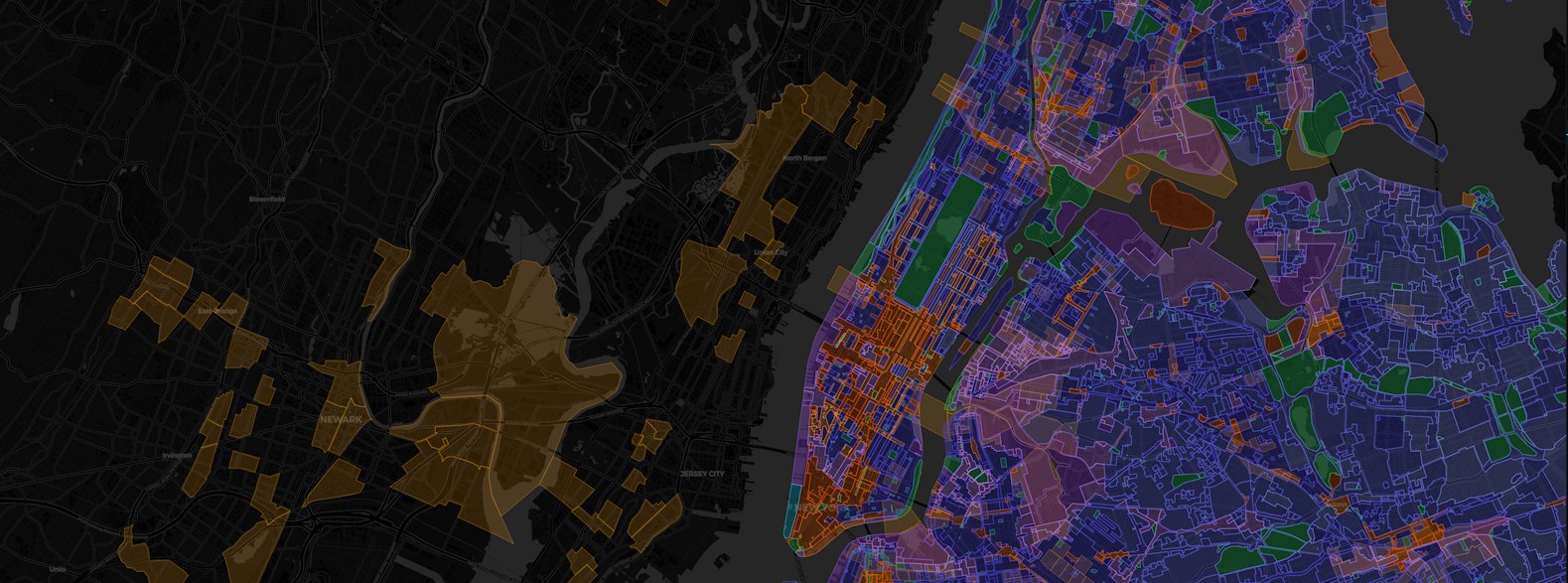 Aerial view of a U.S. metropolitan parcel grid at dusk overlaid with zoning-district boundaries, representing POLYGON's land-use intelligence layers